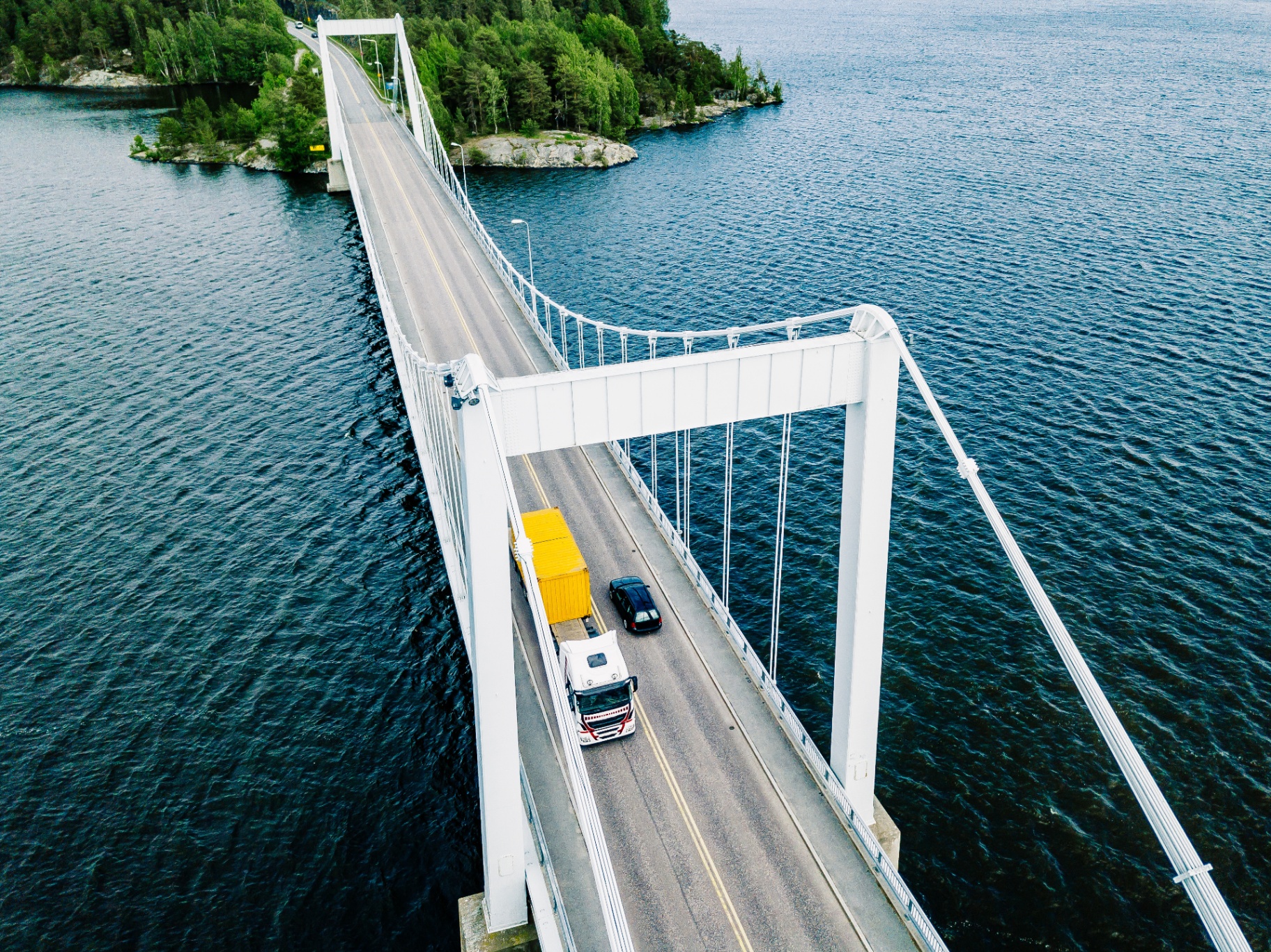 Aerial view of a suspension bridge crossing a lake in Finland